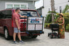 Man folding a Harmar AL300 (base model shown) behind a red minivan