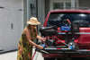Woman fastening a scooter on the platform of a Harmar AL300 (base model shown)