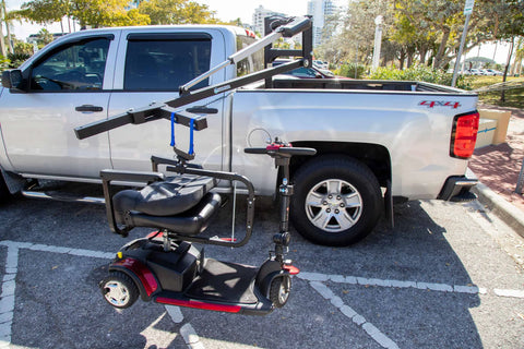 Harmar AL815CC (base model shown) mounted in a silver pickup truck bed next to a red mobility scooter
