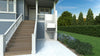 Tall Bruno residential platform lift (VPL-3100/3200B series shown) with a gate, rising beside a front porch stairway