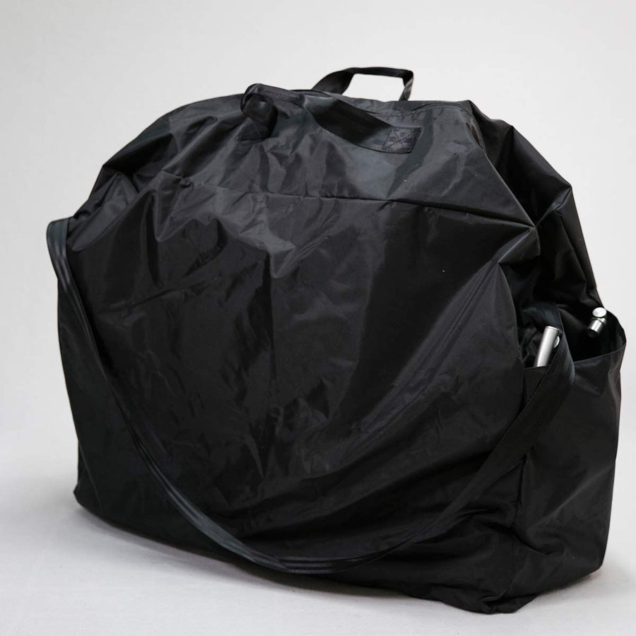 Black nylon wheelchair carry bag, zipped closed, with a top handle and a shoulder strap