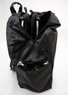 Black carry bag unzipped, with a folded wheelchair frame inside
