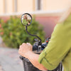 Woman riding a mobility scooter with a Vive mirror clamped to the handlebar