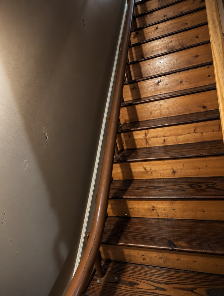 Handicare curved stairlift rail in brown following a turning wooden staircase