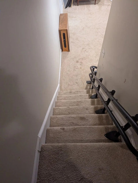 Handicare stairlift rail along carpeted stairs, viewed from the top