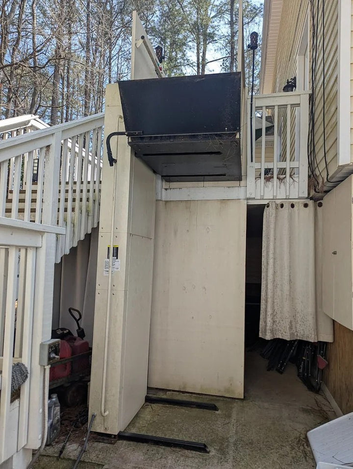 Harmar outdoor vertical platform lift running up the side of a raised deck