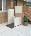 Bruno vertical platform lift beside the front steps of a brick house