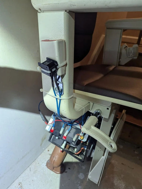 Handicare curved stairlift carriage opened up on the rail, wiring exposed during service