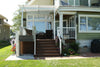Bruno residential platform lift (VPL-3100/3200B series shown) raised to a back porch beside wooden steps